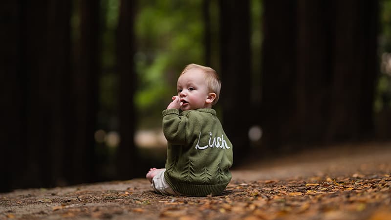 Toddler laughing while playing in a wildflower meadow — Cocomel Portraits