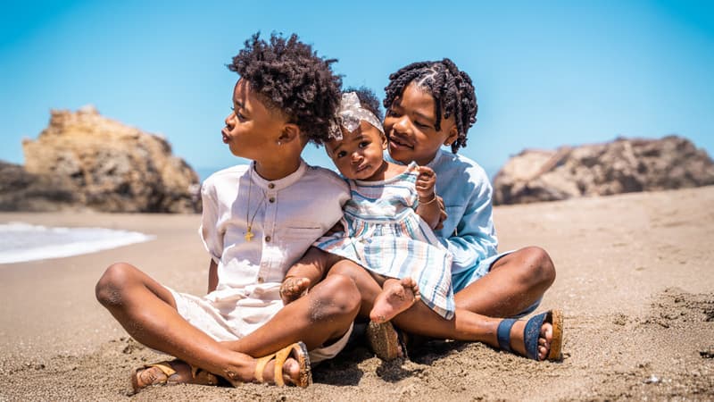Family of four sitting together on a blanket at a Bay Area park — Cocomel Portraits